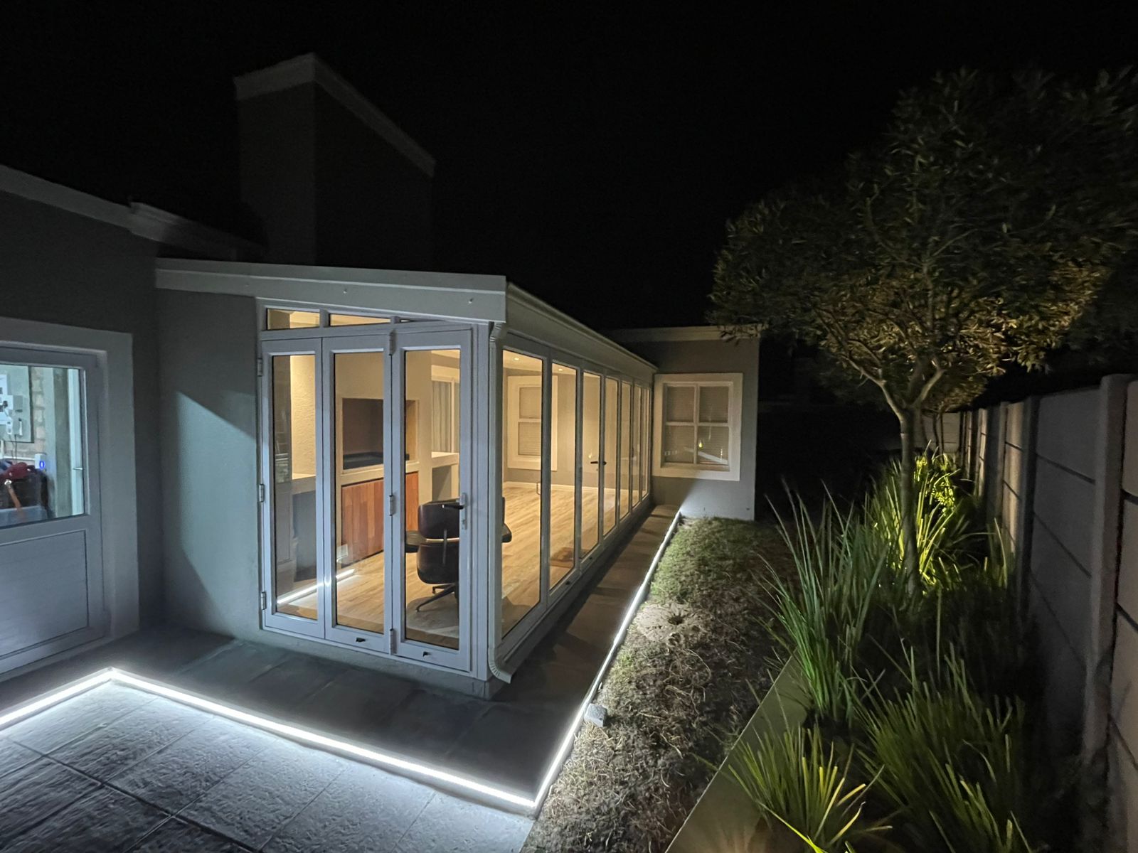 Braai room extension with built in braai, stacker doors and LED garden strip light.
